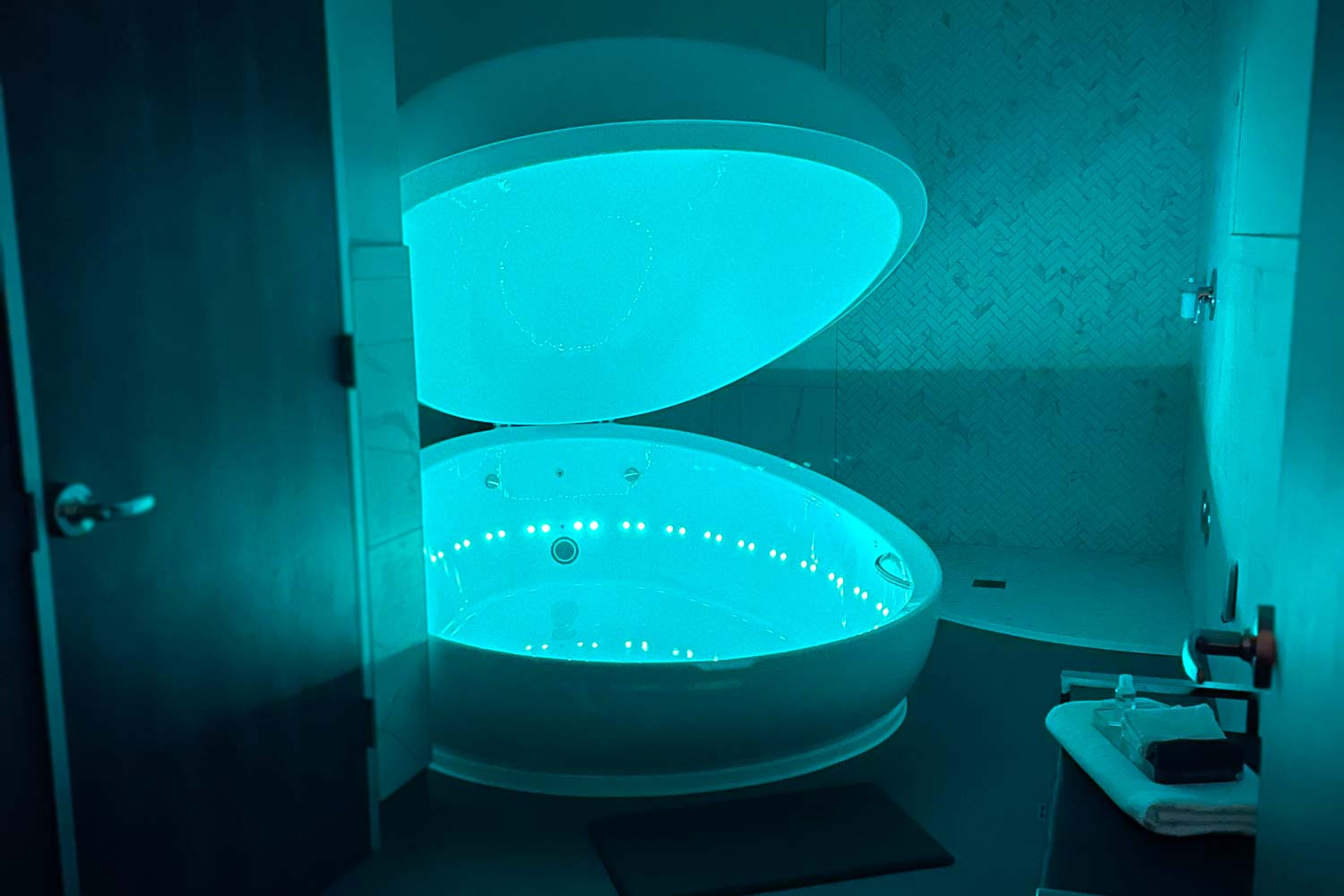 Illuminated float therapy tank in dark room